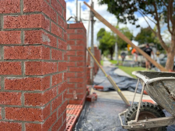 A photo of a bricklayer while working on a brick fencing job in this house in Gold Coast