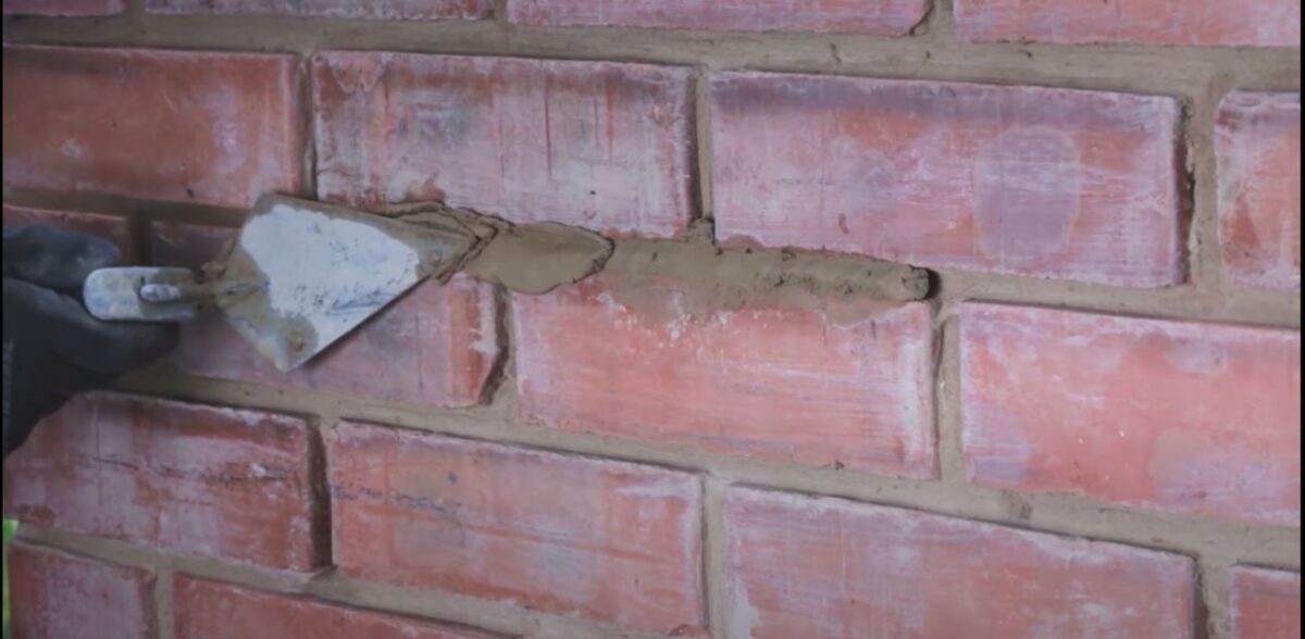 Bricklayer repointing an aged brick fireplace on the Gold Coast