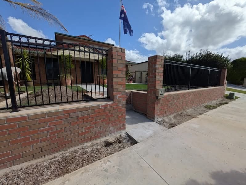 Red brick front fence with piers and ironwork infill on the Gold Coast